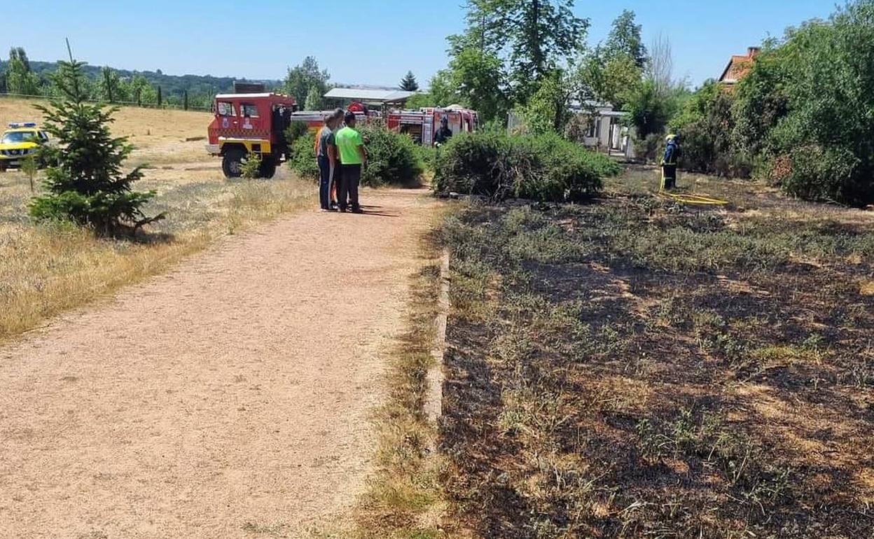 Vecinos y bomberos terminan de sofocar el incendio en el Club de Polo del Real Sitio, este martes. 