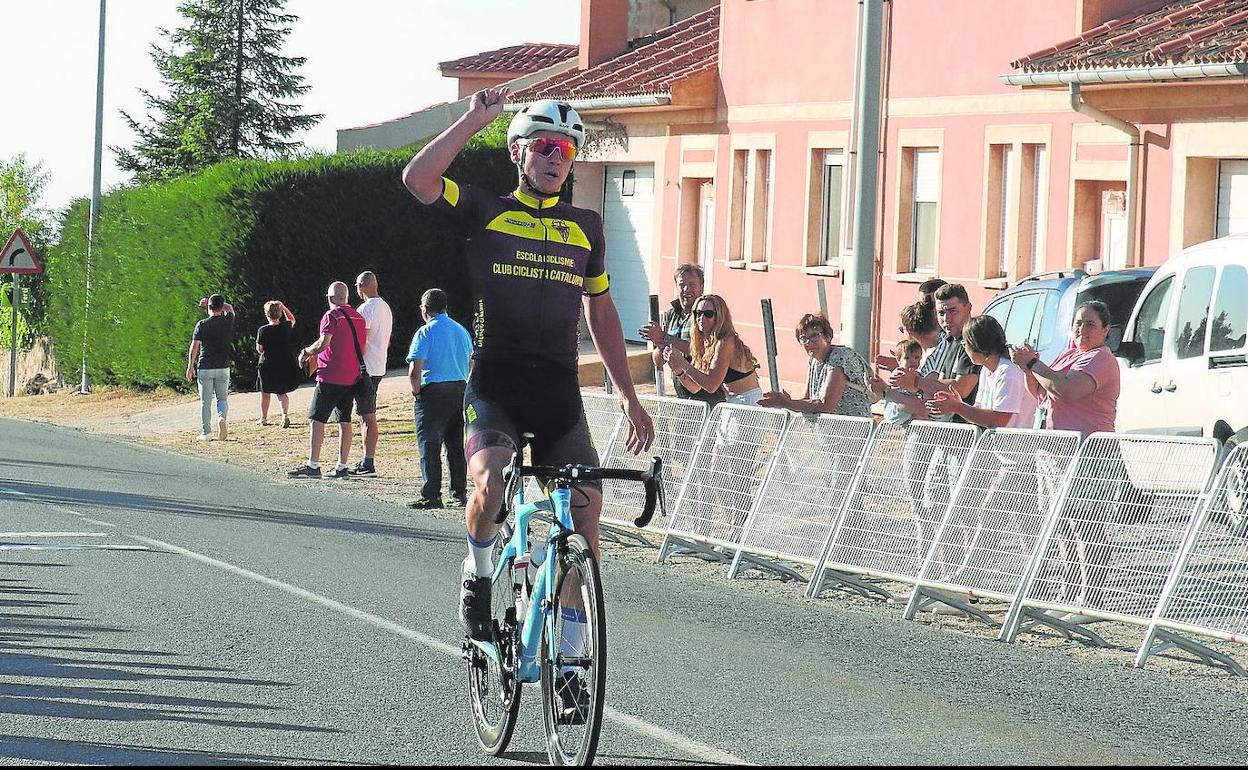 El ciclista ruso Illia Shchegolkov levanta la mano tras imponerse en solitario en Torrecaballeros. 