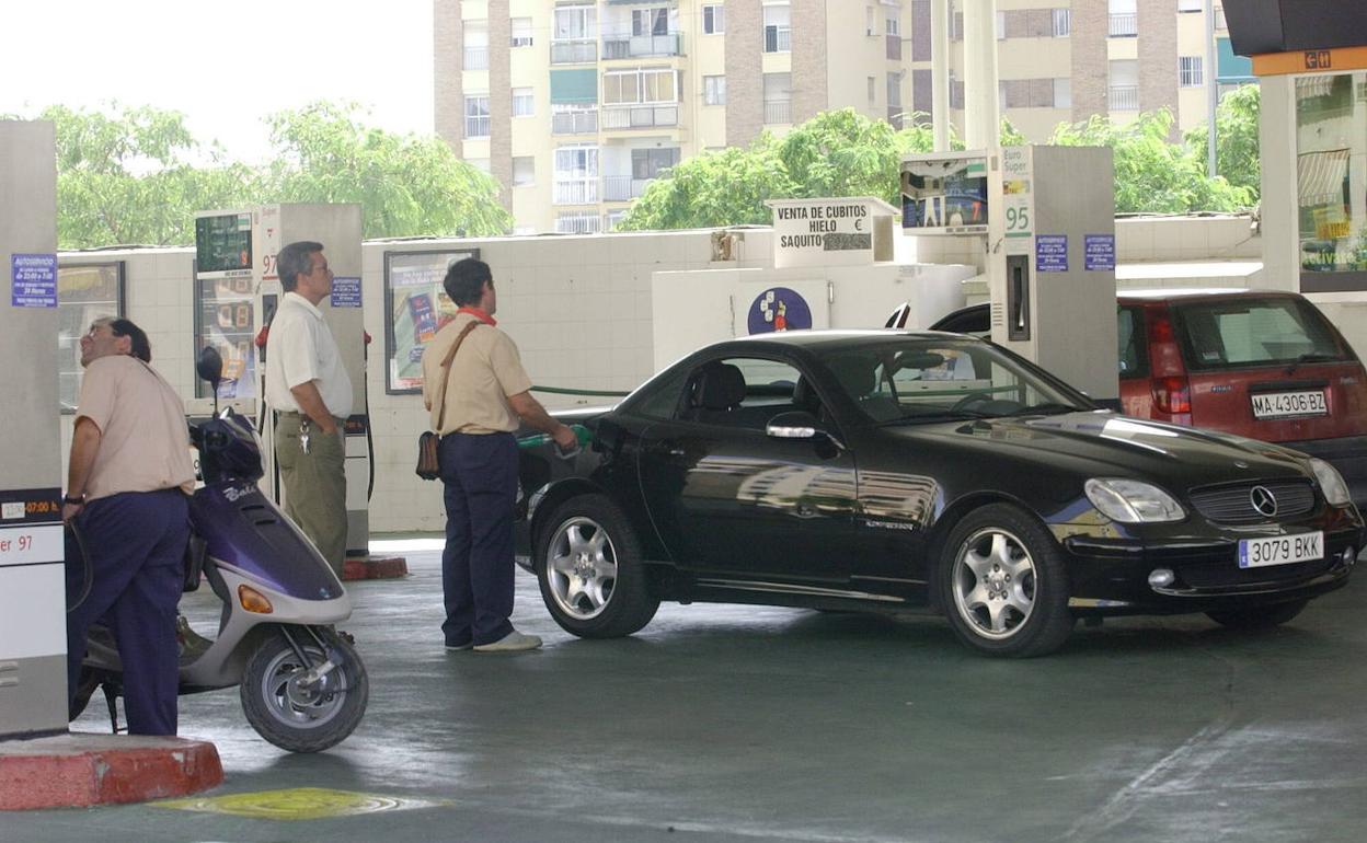 Vehículos y una motocicletas en una estación de servicio. 