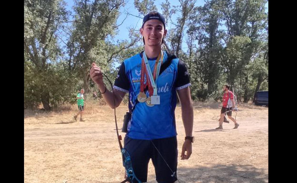 Carlos Iglesias con sus medallas y su arco.