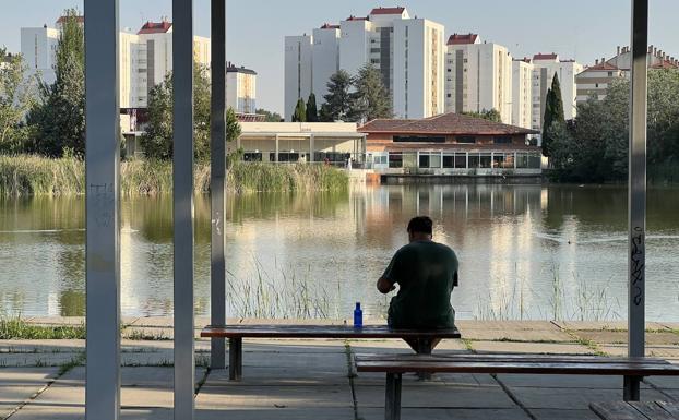 Una persona descansa mirando el lago de Laguna de Duero. 