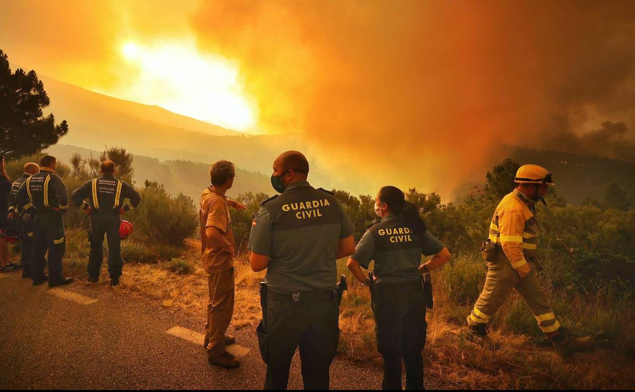 Agentes de la Guardia Civil y de los Bomberos observan el humo y las llamas acercándose a Monsagro desde la zona de Cáceres. 