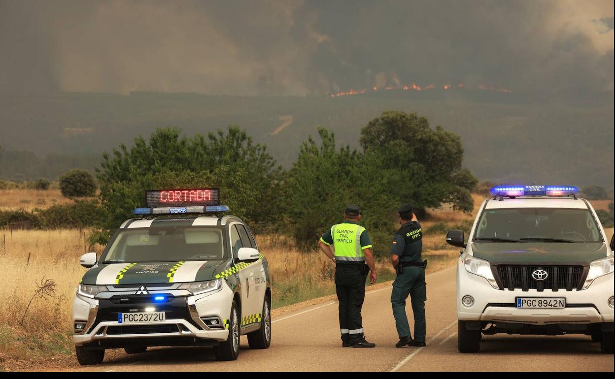 Agentes dela Gaurdia Civil observan el avance de las llamas junto a serradilla del Llano.