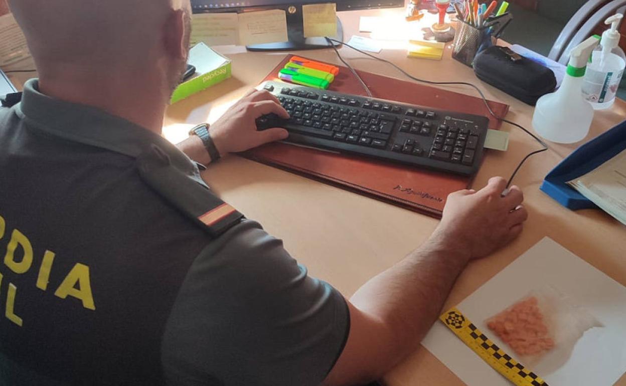Agente de la Guardia Civil con la bolsa de pastillas de éxtasis incautada en la provincia de Segovia. 