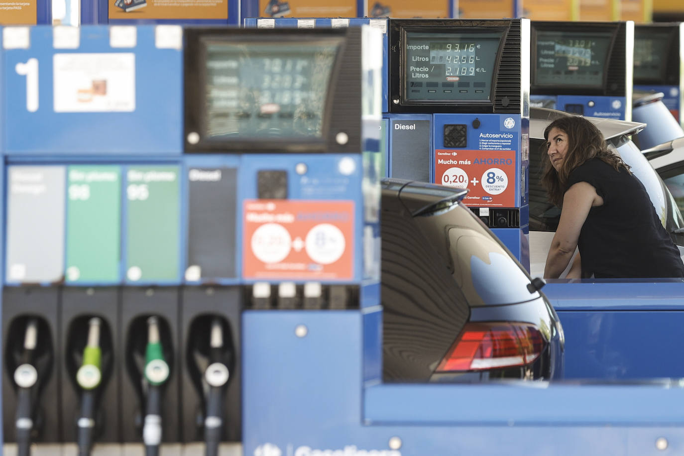 Una conductora reposta en una gasolinera. 