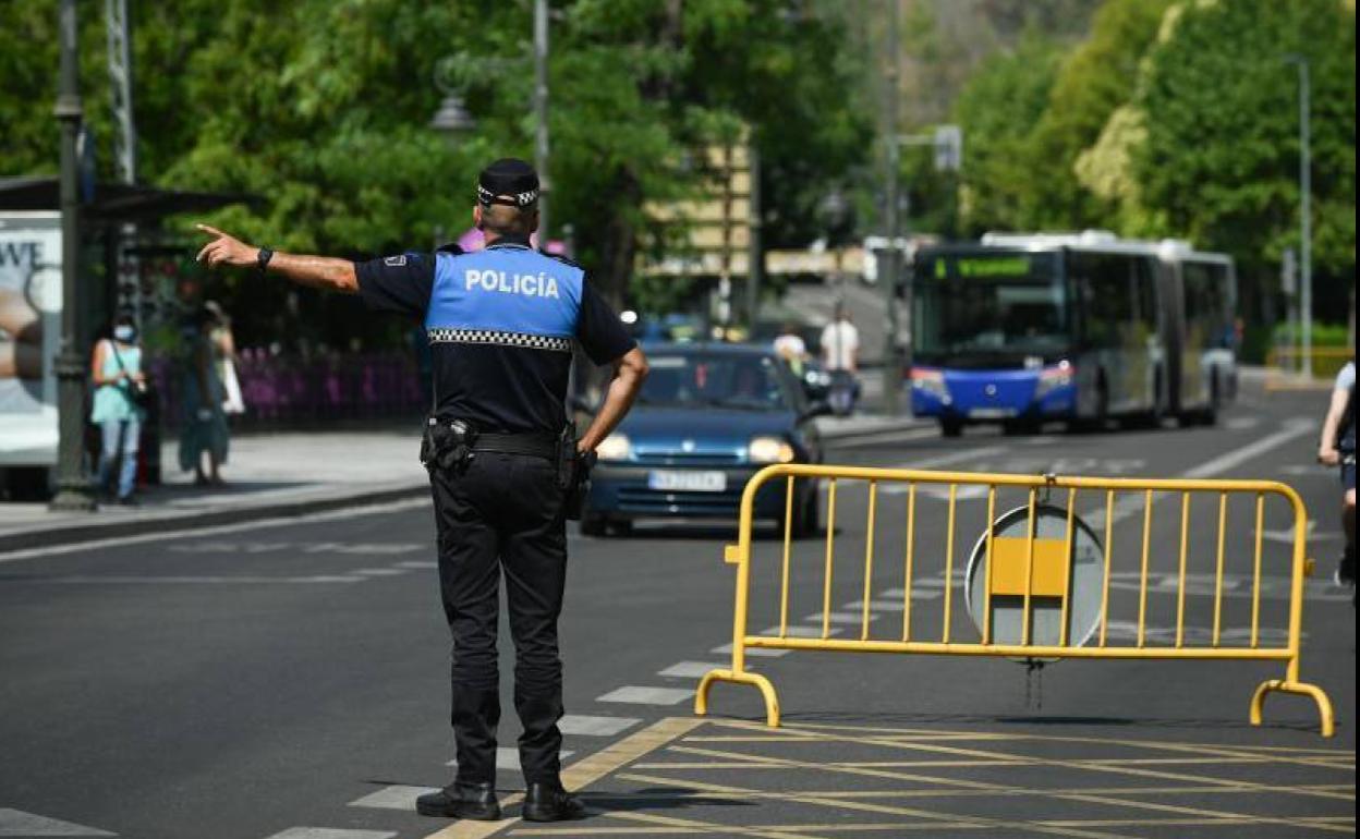 Un policía municipal da instrucciones a los vehículos ante el cierre del centro, este viernes.