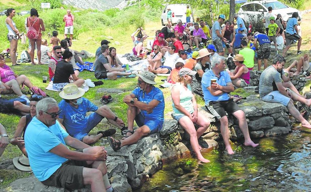 Asistentes a la fiesta de Puente Agudín se refrescan mientras esperan el guiso. 