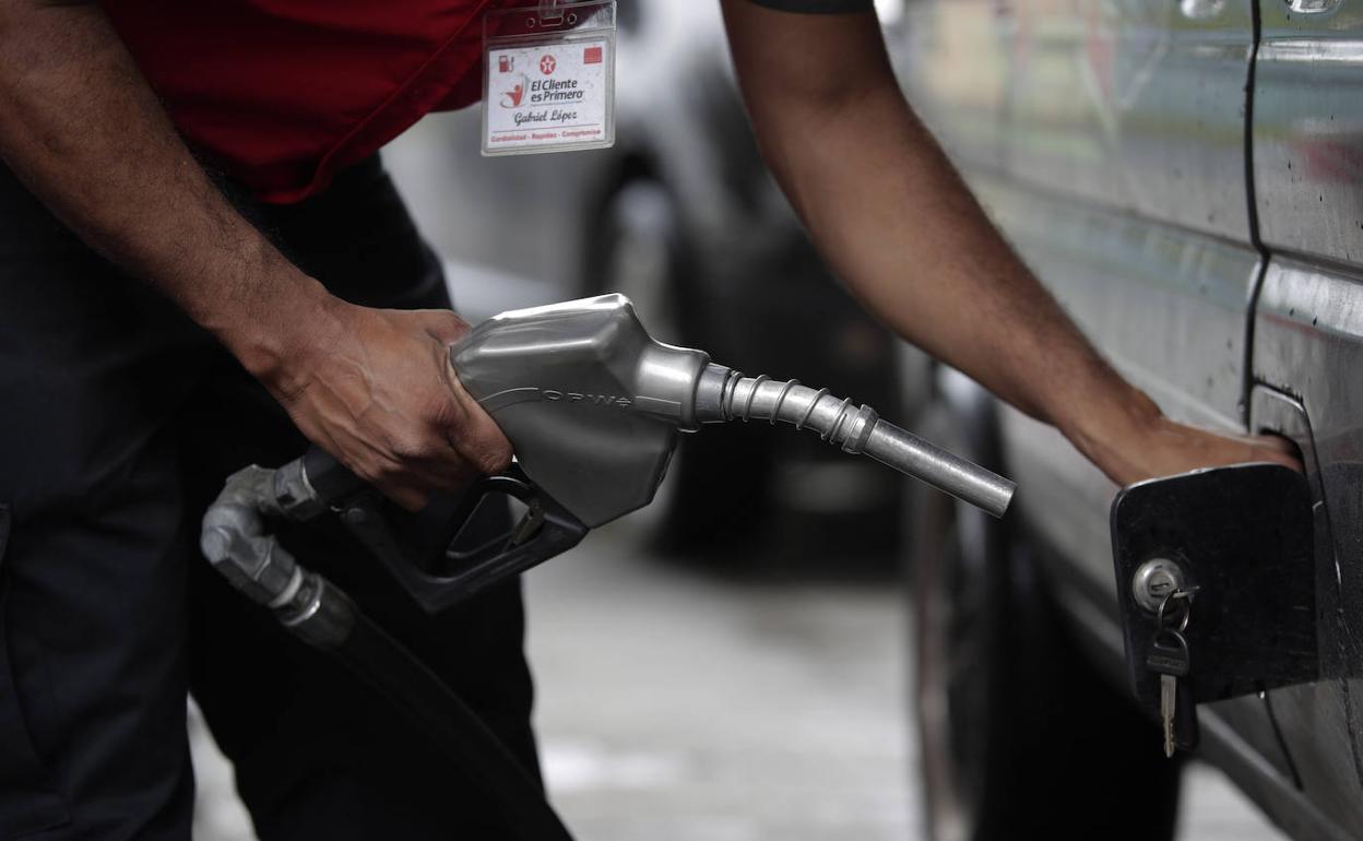 Un operario dispensa combustible en una gasolinera. 