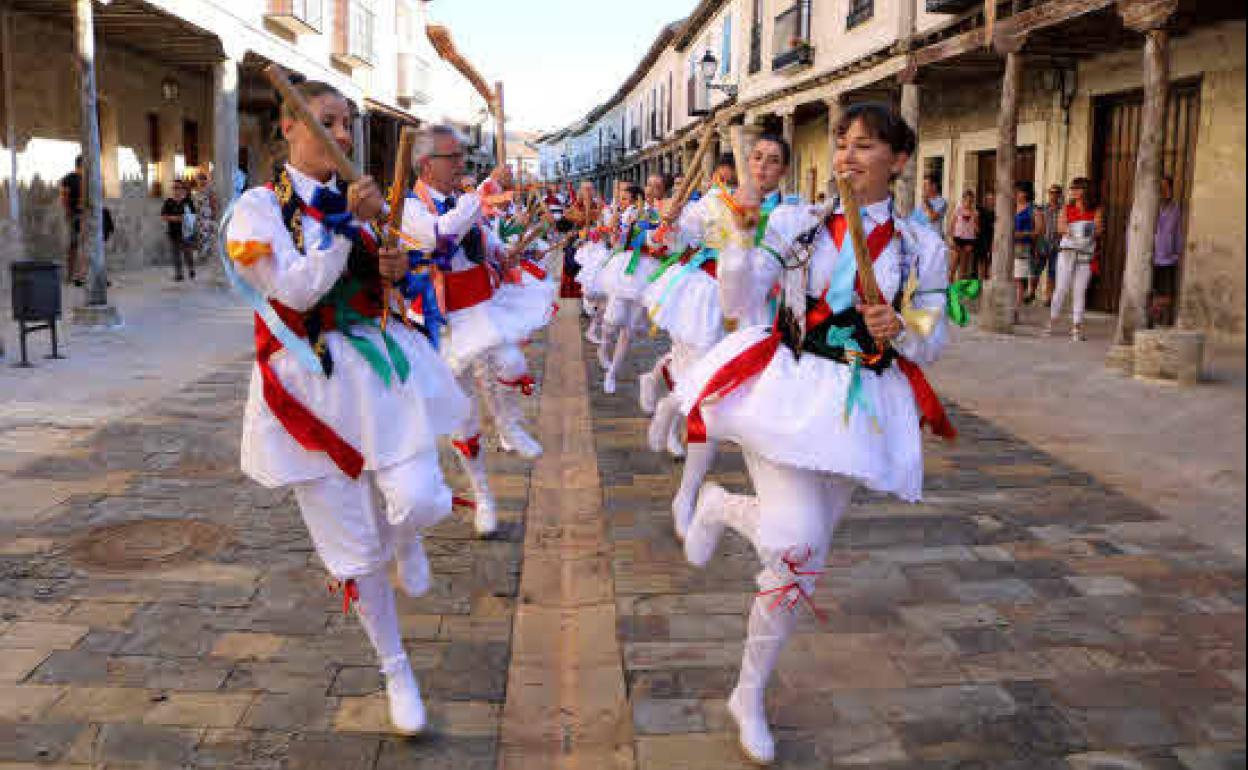 El grupo de paloteo de Ampudia baila por la calle principal, en ell festival de 2018. 