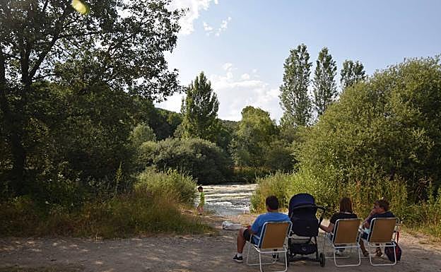 Vecinos senados en el parque junto al río en Mantinos
