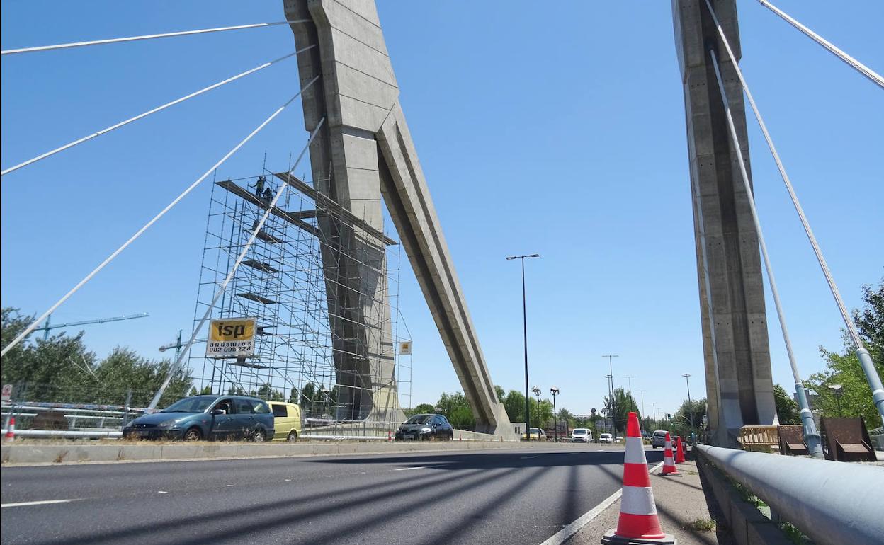 Los operarios retiran los andamios de la vela reparada del puente de Hispanoamérica. 