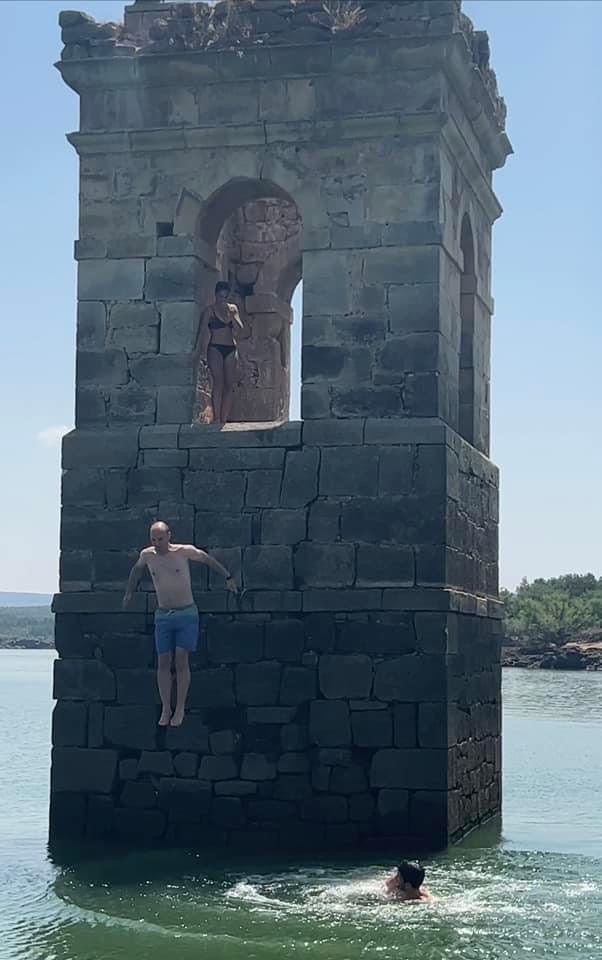 Un grupo de amigos, lazándose al agua desde la torre de La Muedra en el embalse de Cuerda del Pozo. 