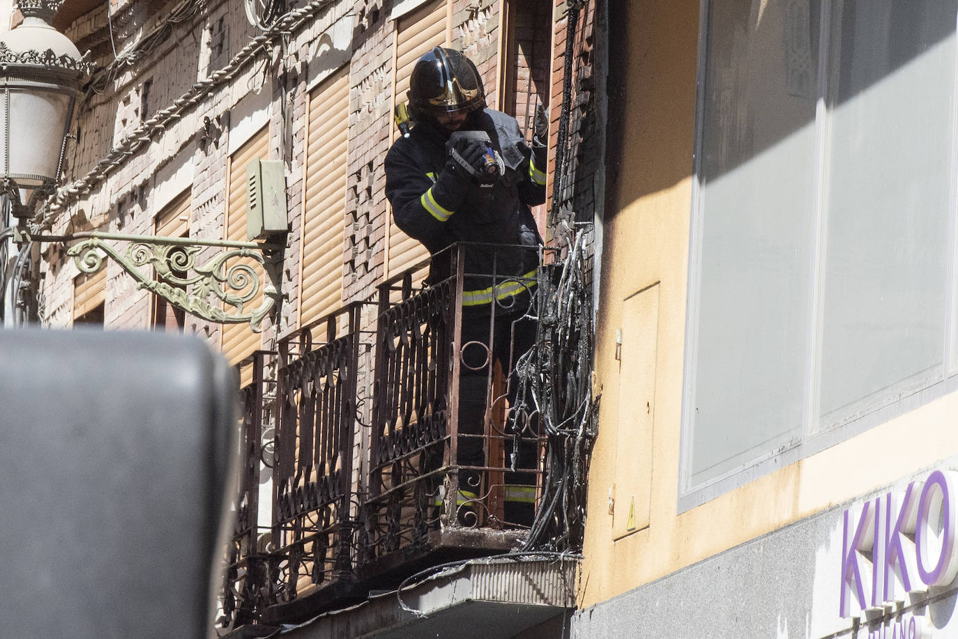 Bomberos acceden al edificio donde ha tenido lugar el incendio tras soficar las llamas en el exterior. 