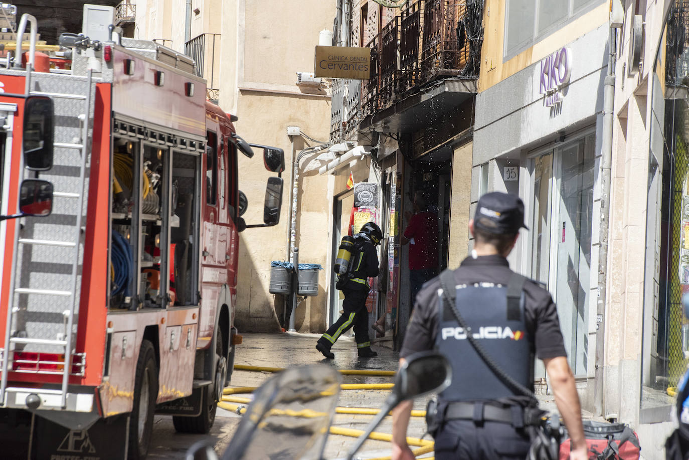 Bomberos acceden al edificio donde ha tenido lugar el incendio tras soficar las llamas en el exterior. 