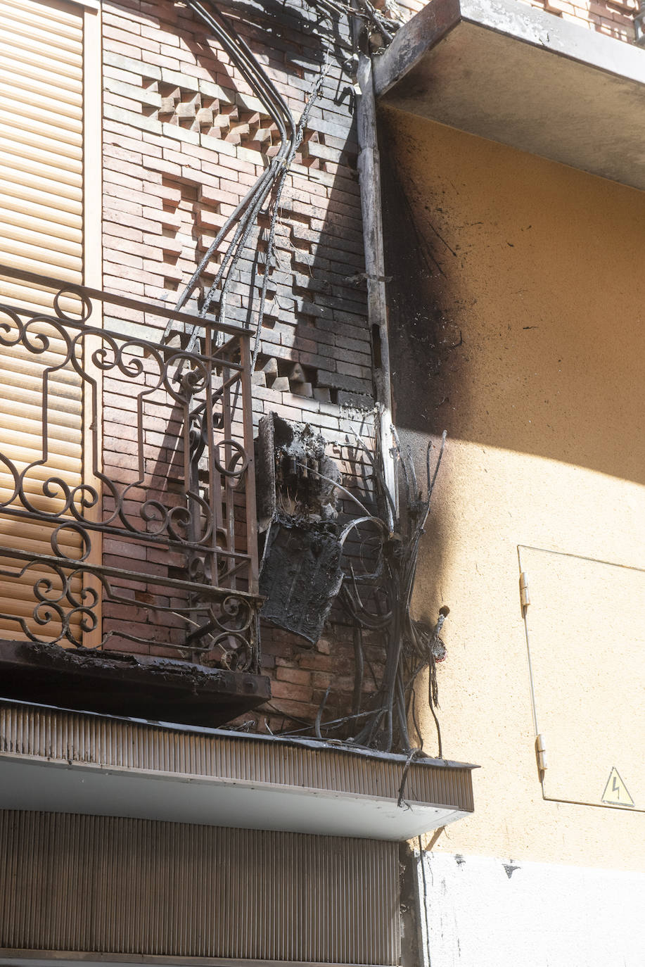 Bomberos acceden al edificio donde ha tenido lugar el incendio tras soficar las llamas en el exterior. 