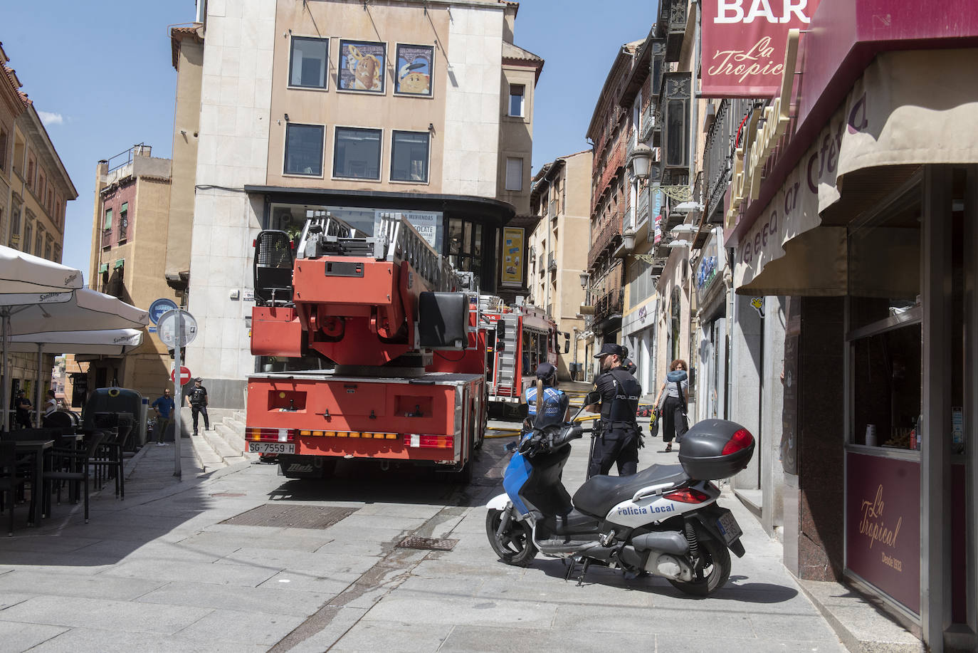 Bomberos acceden al edificio donde ha tenido lugar el incendio tras soficar las llamas en el exterior. 