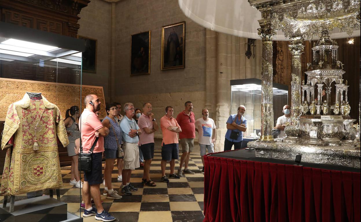 Un grupo de turistas, en visita guiada, ante la custodia de plata que procesiona en el Corpus. 