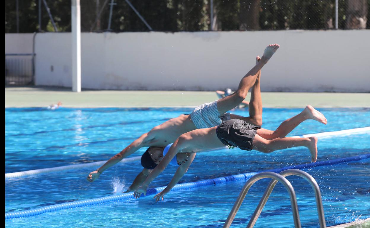 Dos jóvenes se lanzan al agua.