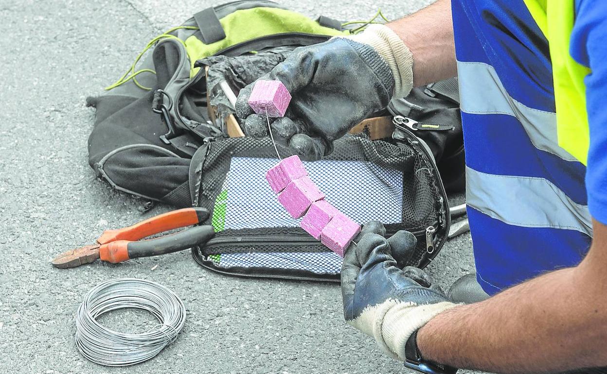 Un operario municipal prepara el veneno que colocará en una alcantarilla de la ciudad para el control de plagas. 