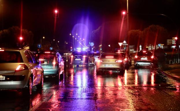 Las luces de los vehículos se reflejan en el asfalto durante la lluvia