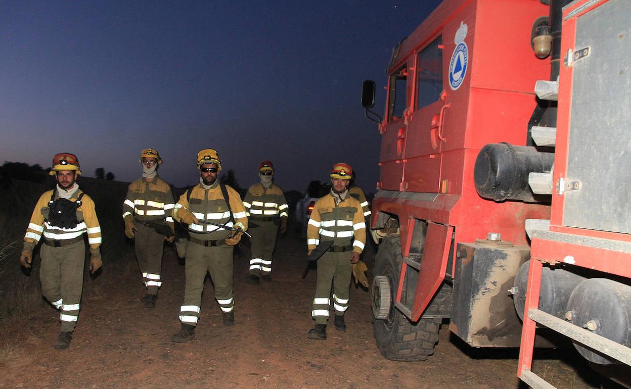 Bomberos trabajan durante la noche de este sábado en el control del incendio forestal de Becerril.