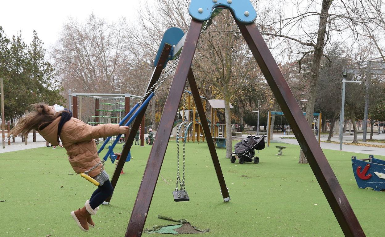 Una niña se columpia en un parque de Palencia. 