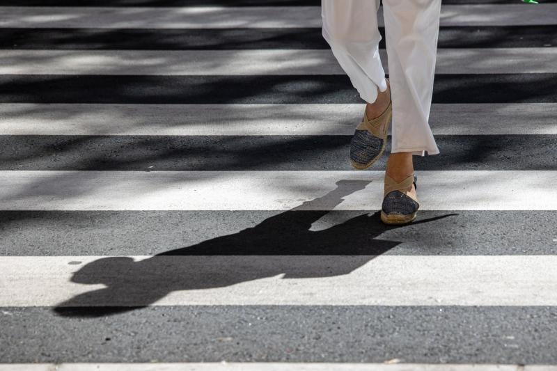 Una mujer cruza por un paso de peatones.