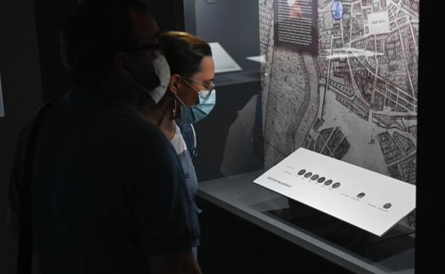 Dos personas contemplan la exposición numismática en el Museo de Valladolid. 