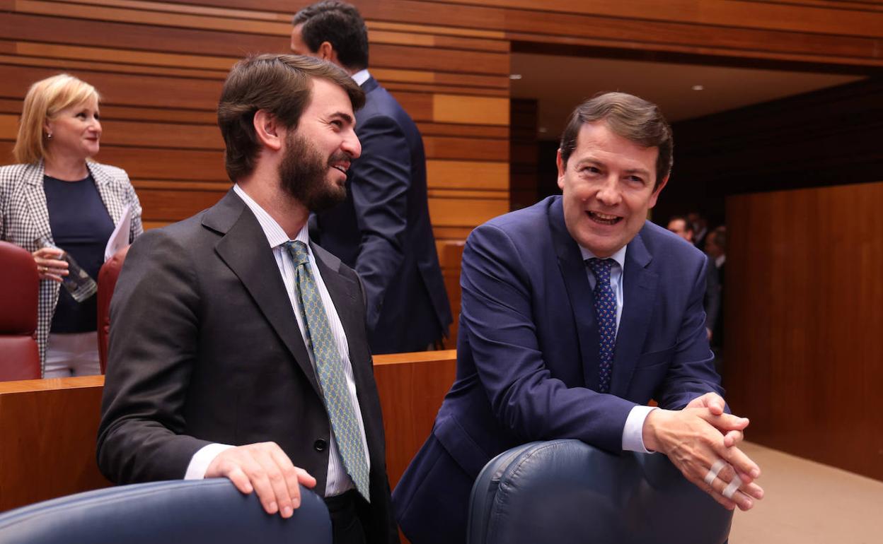 Juan García-Gallardo y Alfonso Fernández Mañueco conversan en el hemiciclo de las Cortes de Castilla y León.