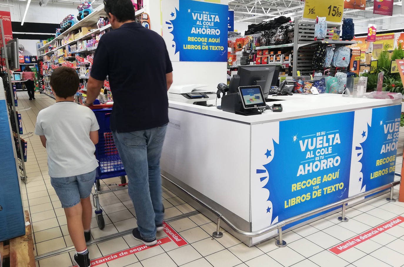 Un hombre compra con su hijo material escolar.