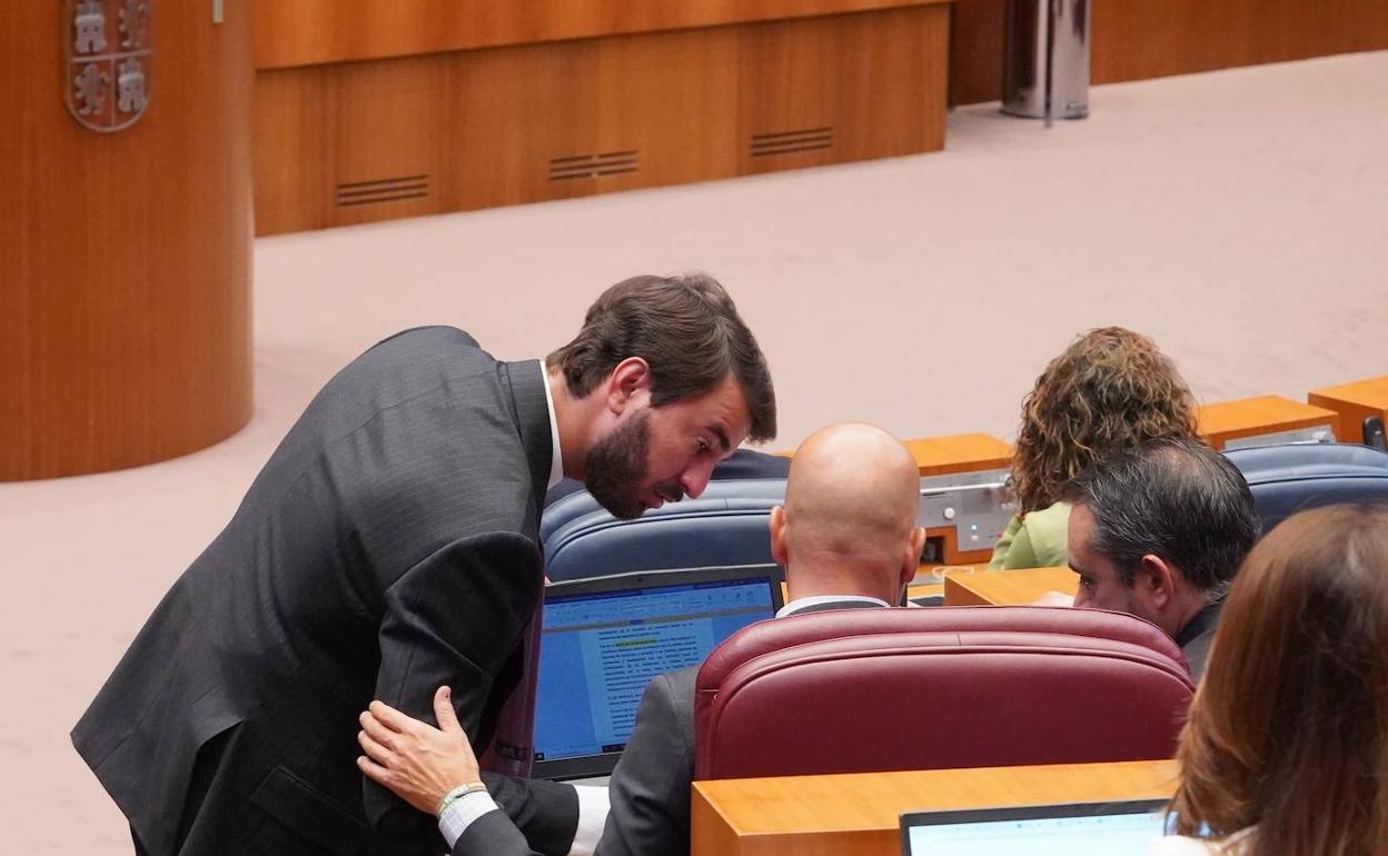 Juan García-Gallardo conversa durante el pleno con el portavoz de Vox, Carlos Menéndez.