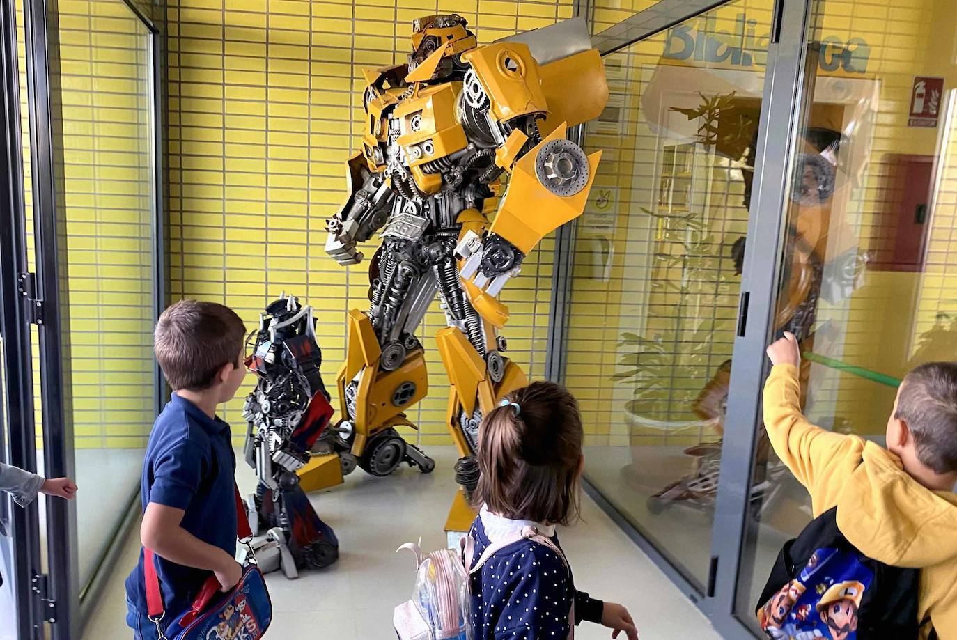 Alumnos del colegio de Valverde observan a los dos 'transformers' situados a la entrada del centro.
