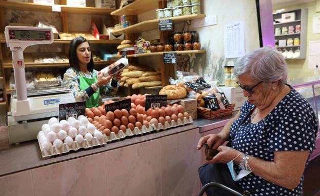 Una mujer compra una docena de huevos en un puesto de la Plaza. 