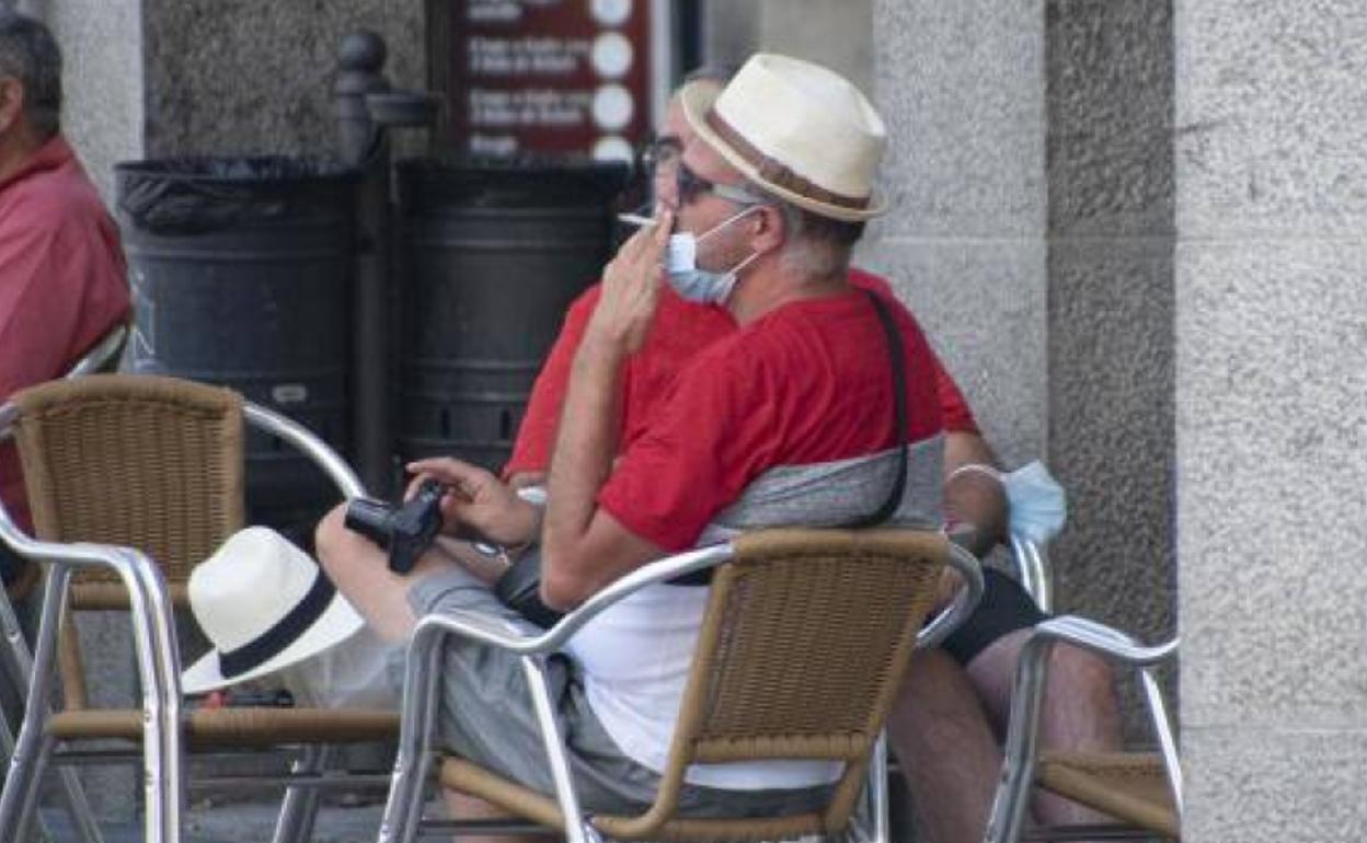 Un hombre fuma en la terraza de un establecimiento.