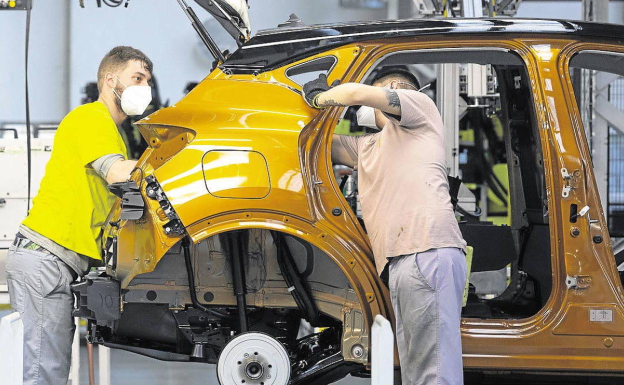 Dos trabajadores de Renault en la factoría de Montaje en Valladolid junto a un modelo Captur. 