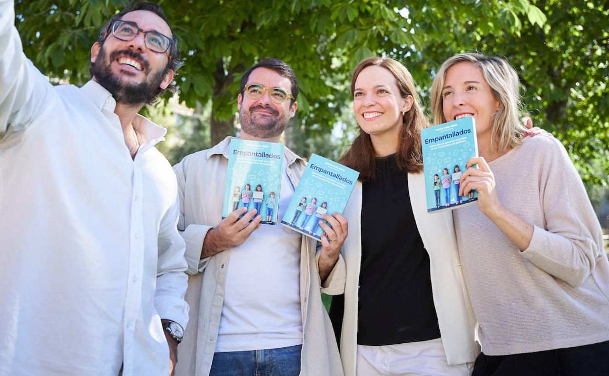 Los cuatro trabajadores del proyecto y autores del libro 'Empantallados' posan con varios ejemplares. 