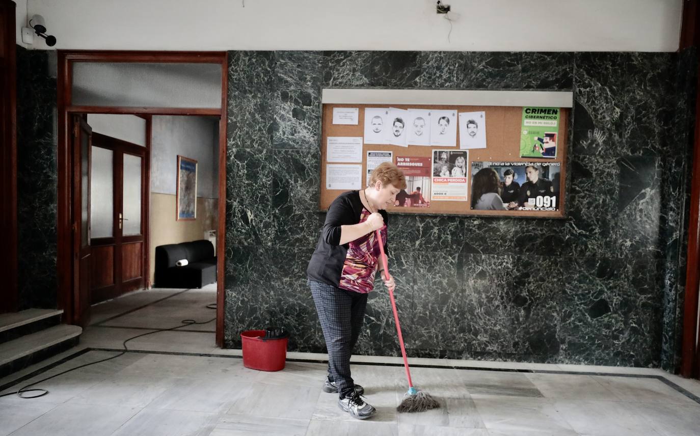 Una trabajadora limpia el vestíbulo de El Salvador, en el que hay varias fotos con los delincuentes más buscados de la serie.