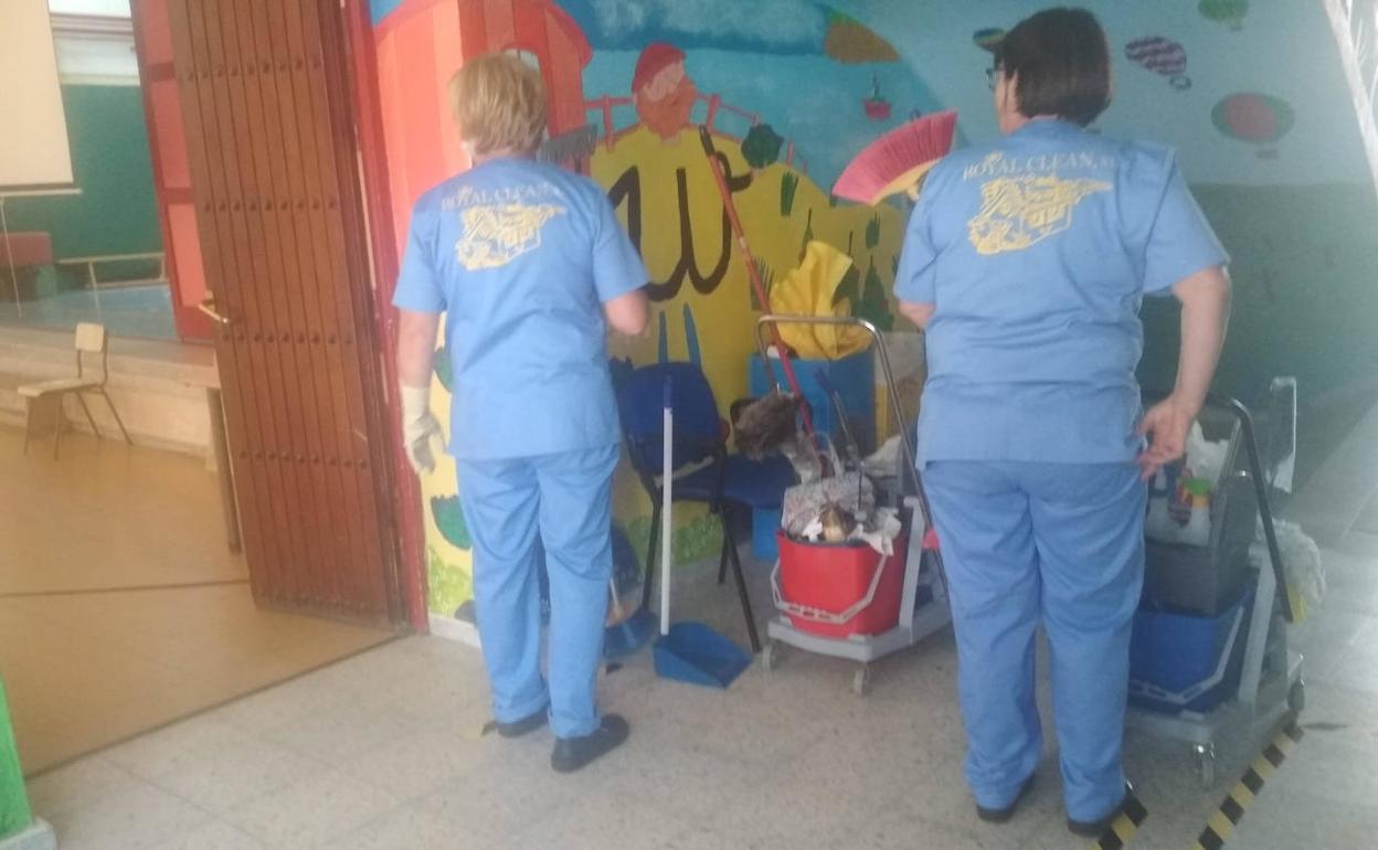 El personal de limpieza realiza labores en una de las aulas. 