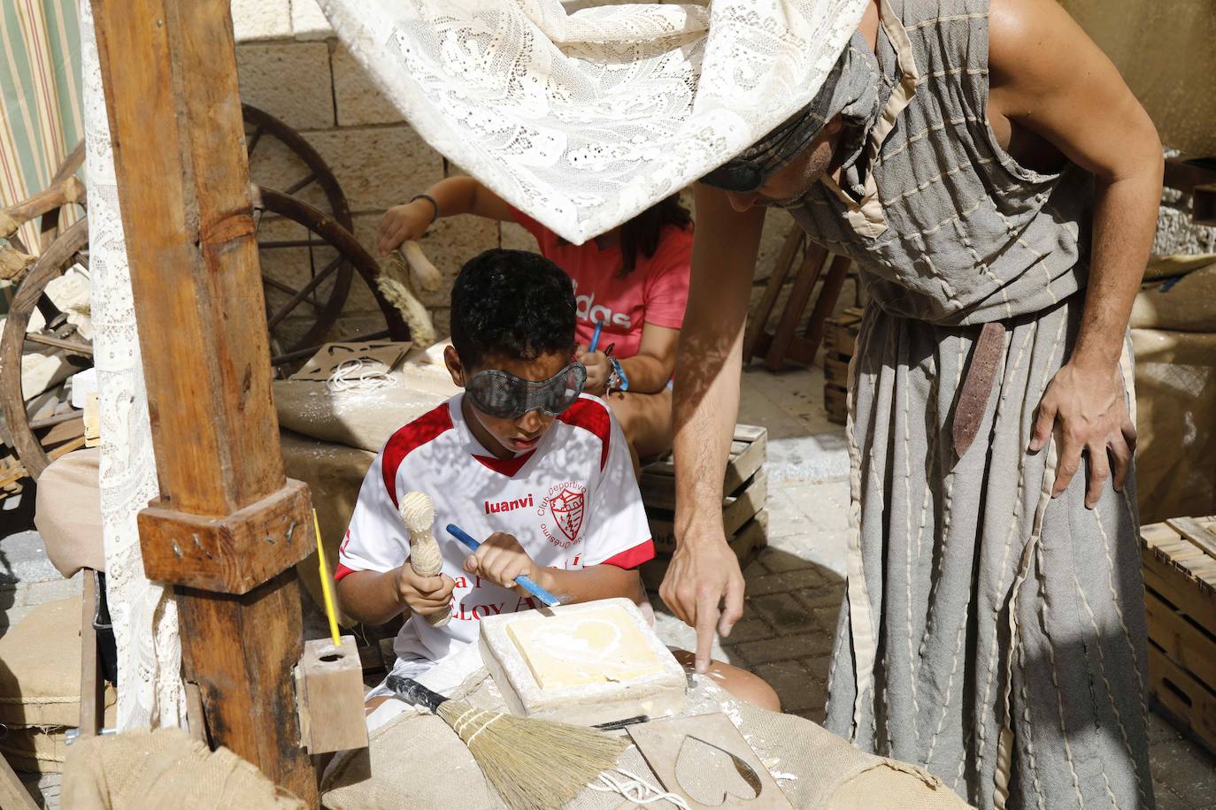 Dos niños pisan la uva para extraer el mosto en la plaza de Quintanilla.