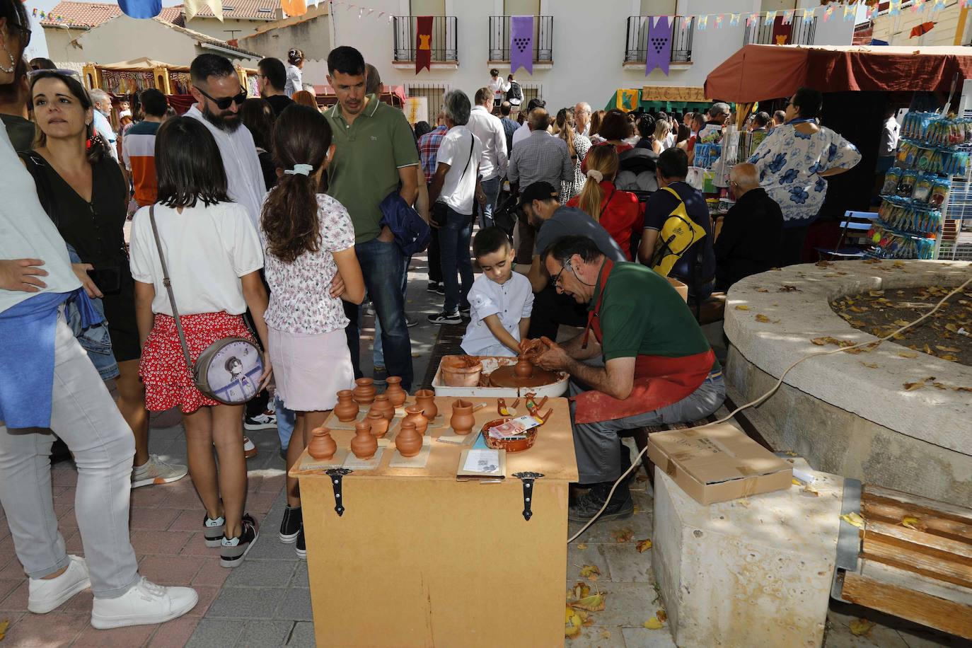 Dos niños pisan la uva para extraer el mosto en la plaza de Quintanilla.