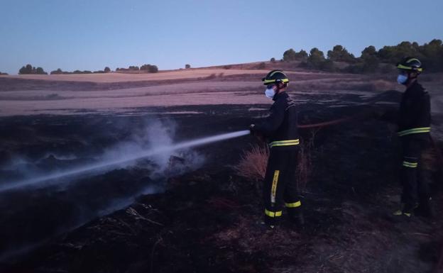 Dos efectivos del cuerpo de extinción durante los trabajos para sofocar las llamas.