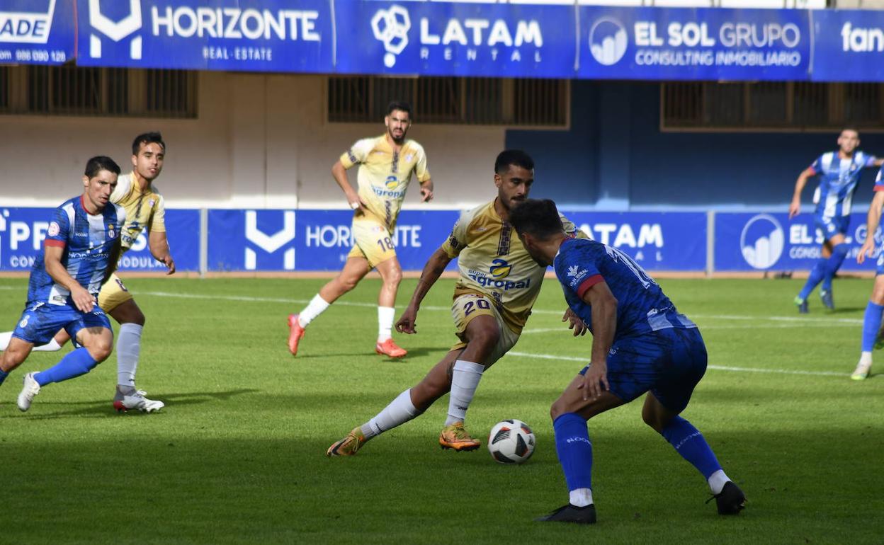 Adrián Castro dirige la jugada ante un rival del Real Avilés, ayer en el Román Suárez Puerta. 