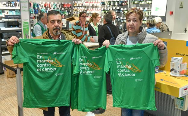 Dos de los ya inscritos en la Marcha contra el cáncer posan con sus camisetas. 