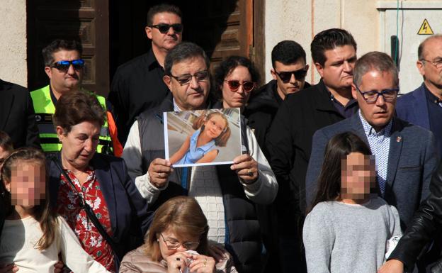 El abuelo paterno de la niña sujeta una foto de Olivia sonriente durante la conecntración de este martes en Torrecaballeros. 