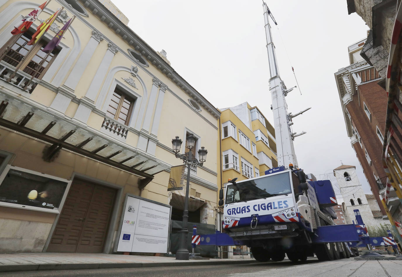 Una grúa de grandes dimensiones trabaja en la calle Burgos para colocar decenas de vigas de madera de tamaño gigante.