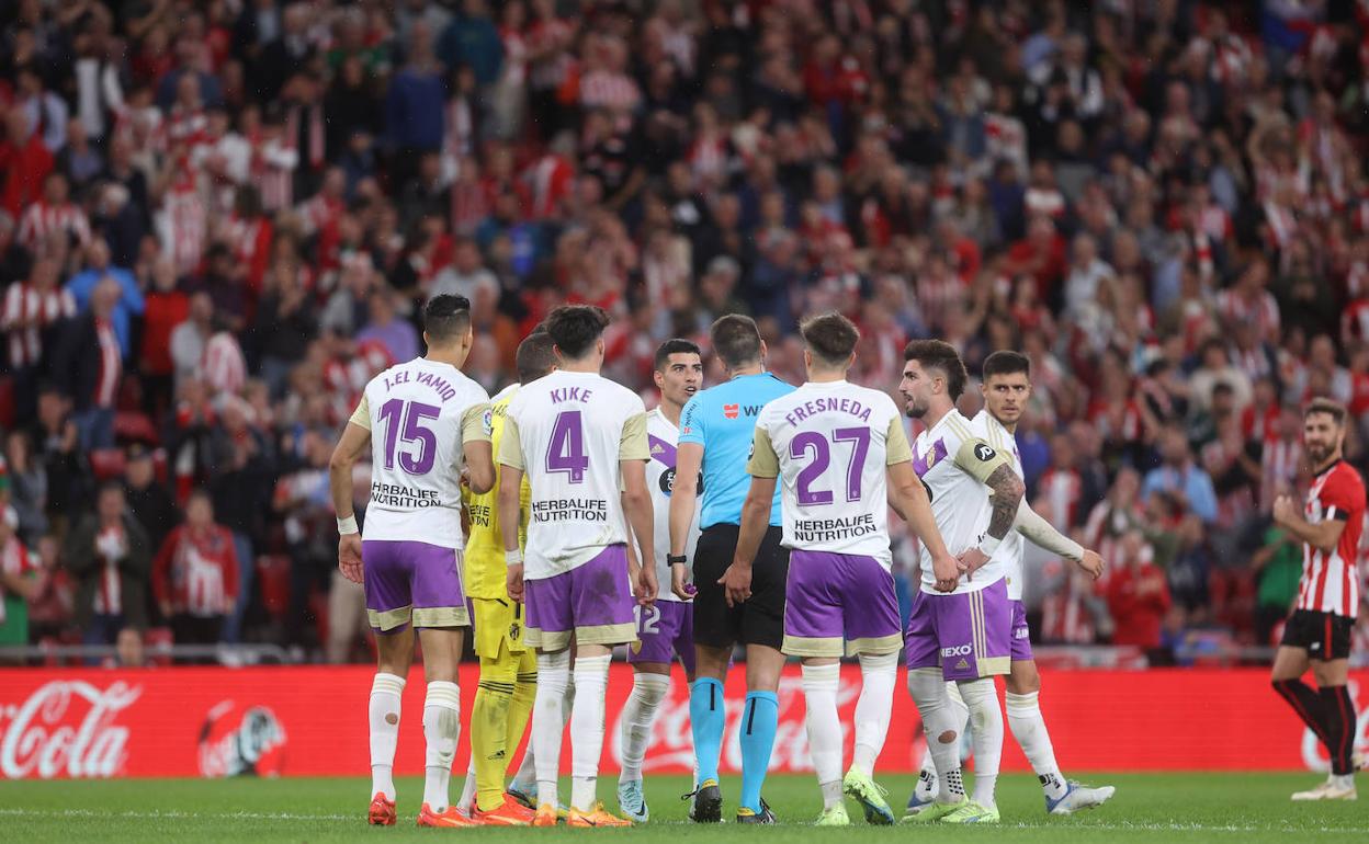 Jugadores del Real Valladolid piden explicaciones al colegiado.