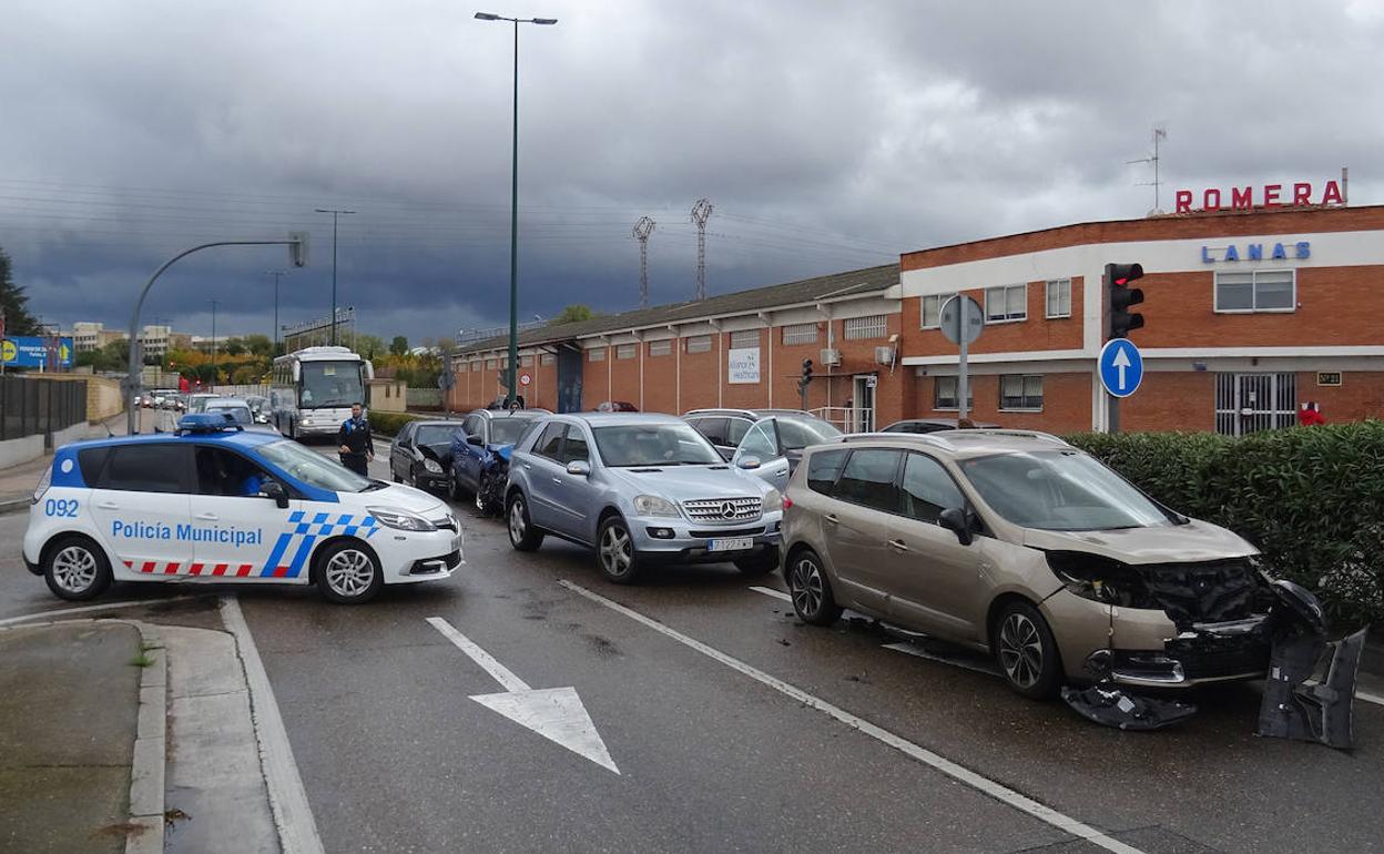 Una patrulla regula el tráfico junto a los turismos siniestrados en el polígono de Argales. 