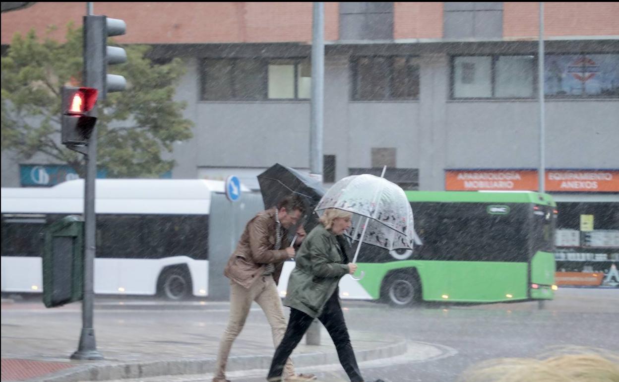 Dos personas se protegen de la lluvia en Valladolid.
