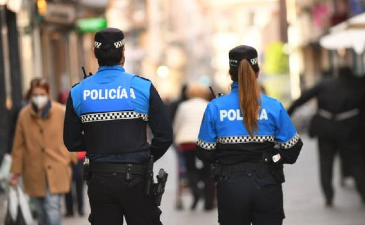 Dos agentes de la Policía Municipal recorren a pie la céntrica calle Santiago de Valladolid.