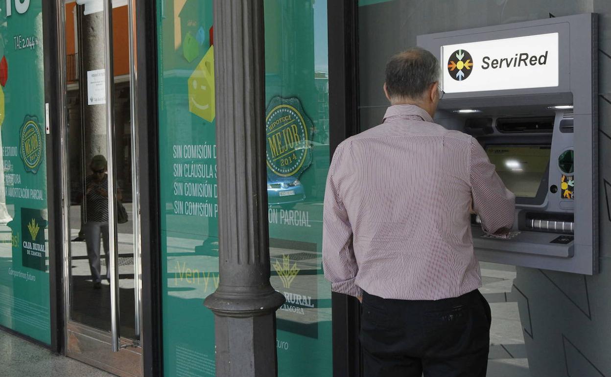 Un hombre hace uso de un cajero automático en Valladolid. 